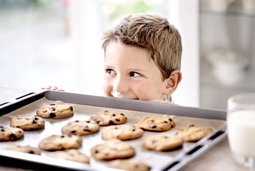 Dreng foran en plade cookies