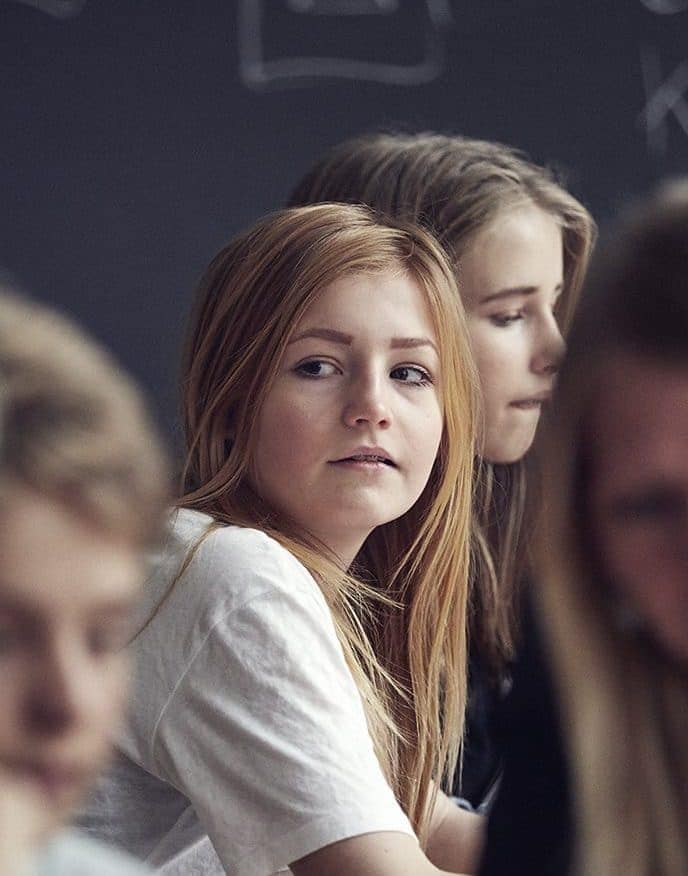 Pige i klasselokale kigger til siden