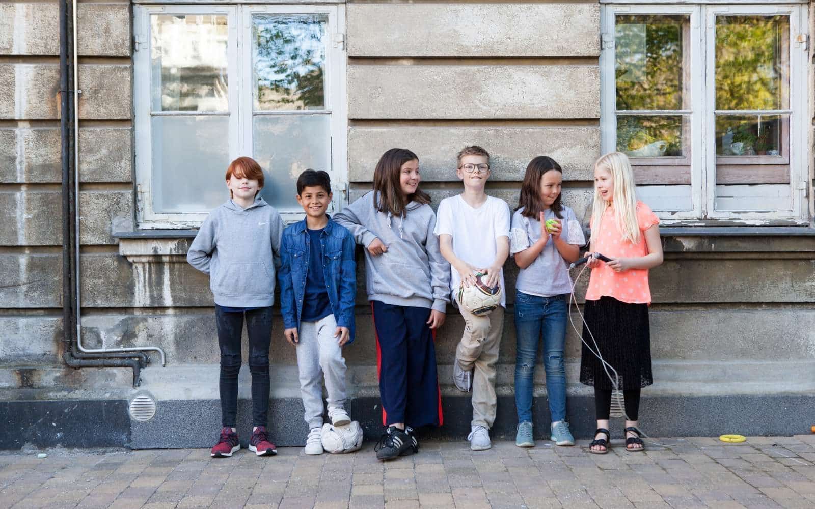En gruppe børns står op ad en mur