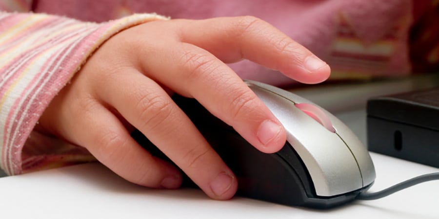 Barnehånd holder på en mus