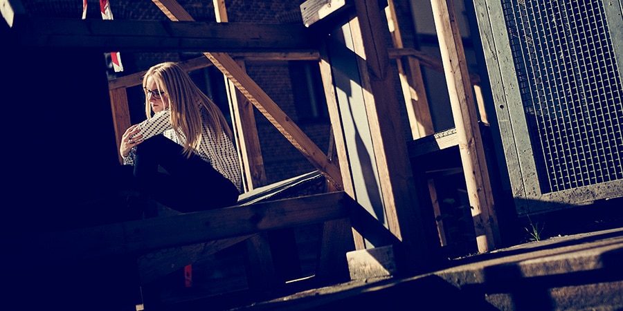 Lyshåret kvinde sidder udenfor