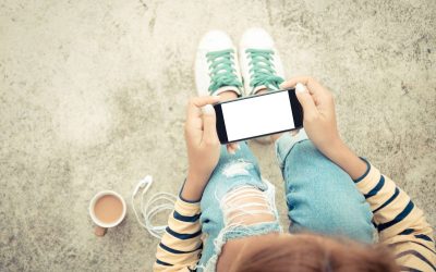 Barn der holder en mobil set oppefra