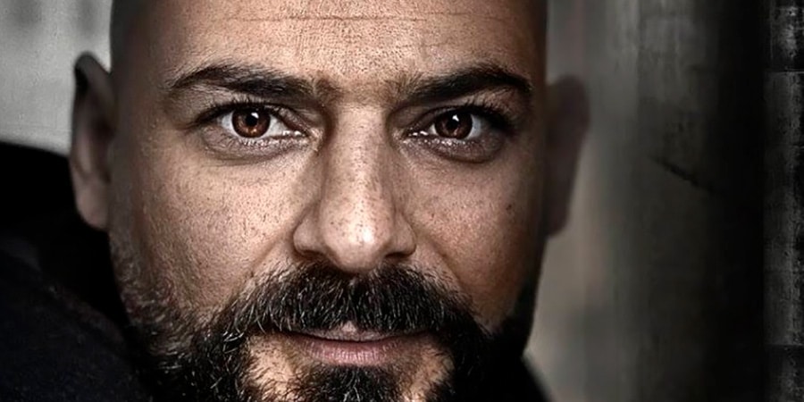 Mand med mørkt skæg kigger ind i kameraet