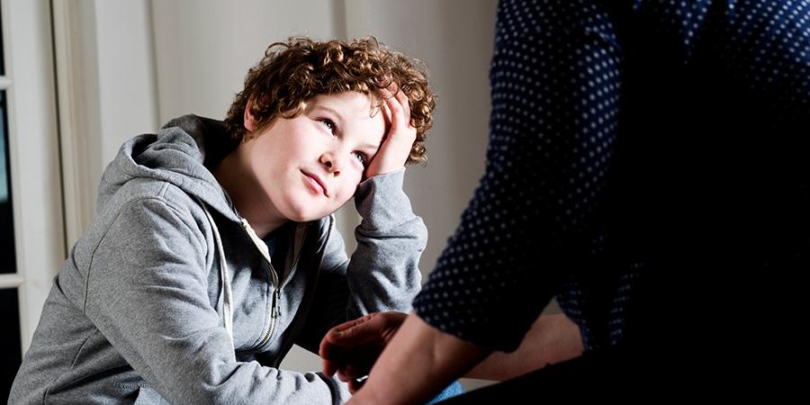 Dreng med krøller kigger op på en voksen