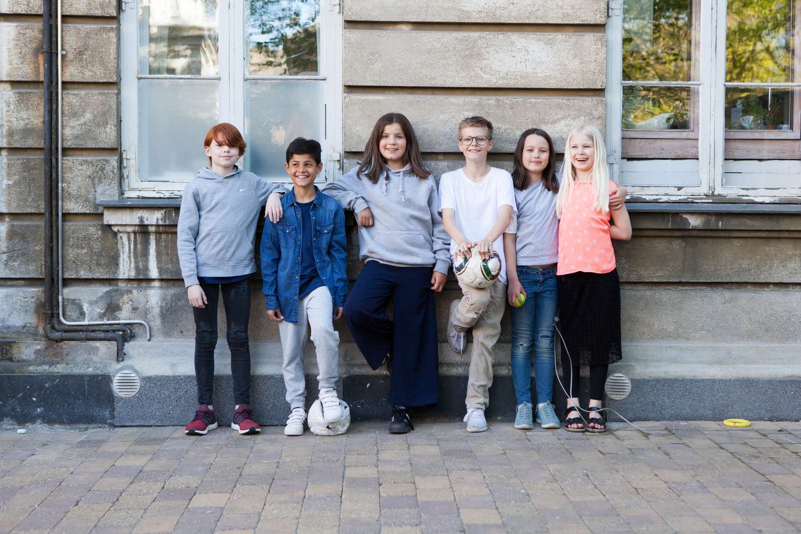 Seks børn foran en væg.