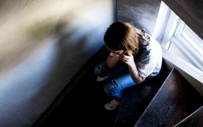 Brunhåret pige sidder på en trappe og taler i telefon