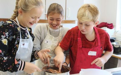 Tre børn står og smelter chokolade