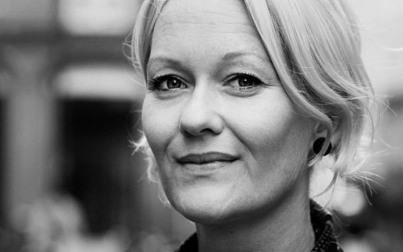 Sort-hvidt billede af en blond kvinde der kigger ind i kameraet