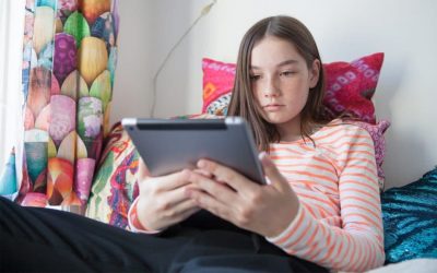 Pige med iPad i sin seng