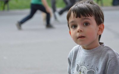 Dreng sidder alene i en skolegård