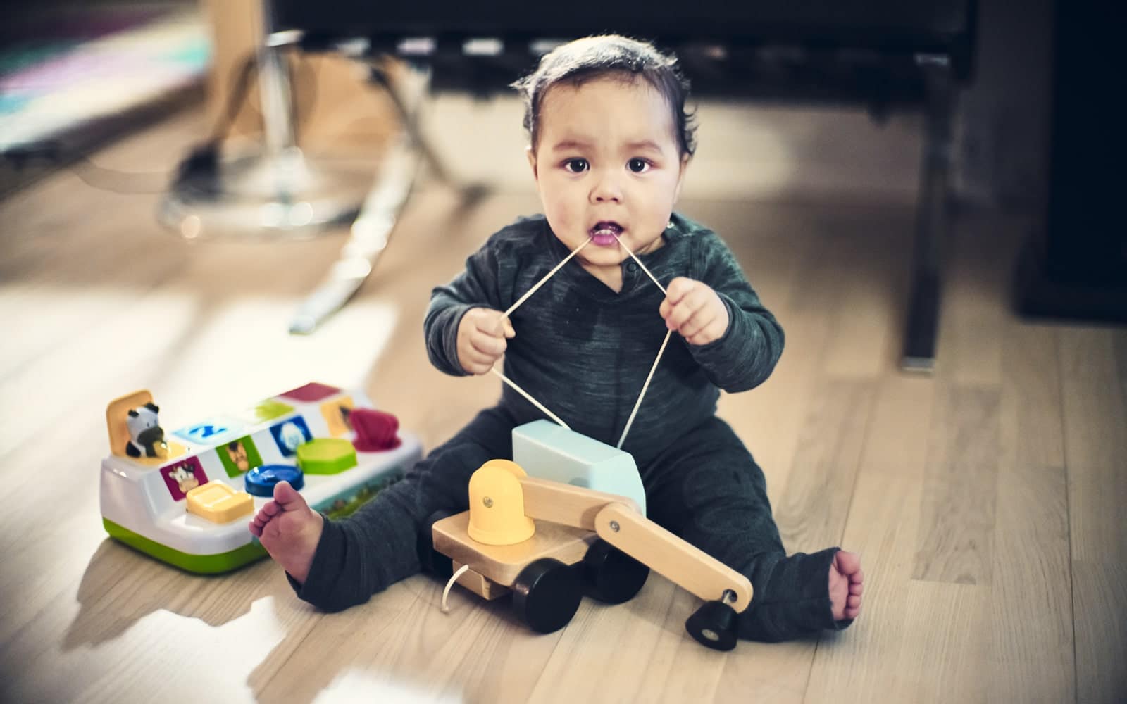 Baby sidder på gulvet og leger