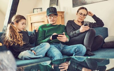 Familie på sofa sidder på hver sin skærm