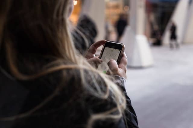 Pige set baggfra kigger på sin telefon