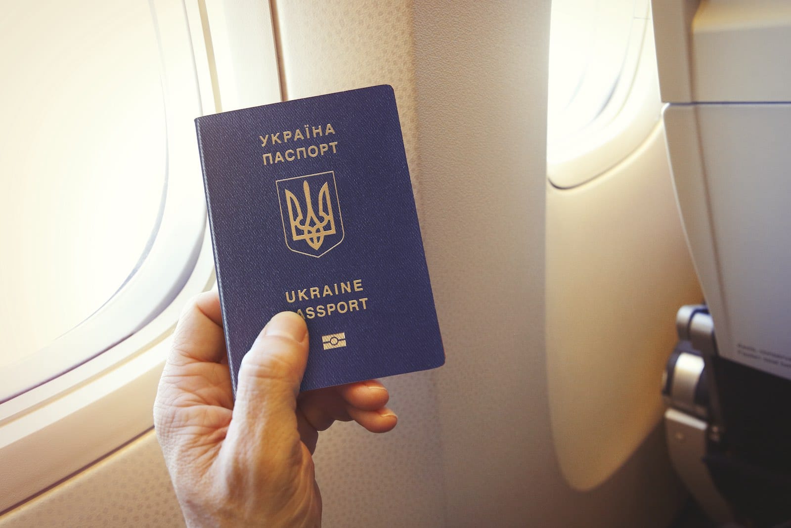 Passager holder et ukrainsk pas ombord på et fly