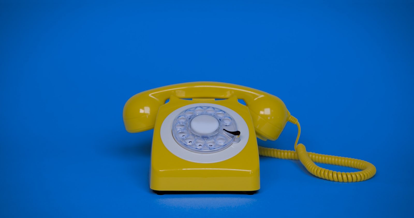 En gul telefon på blå baggrund
