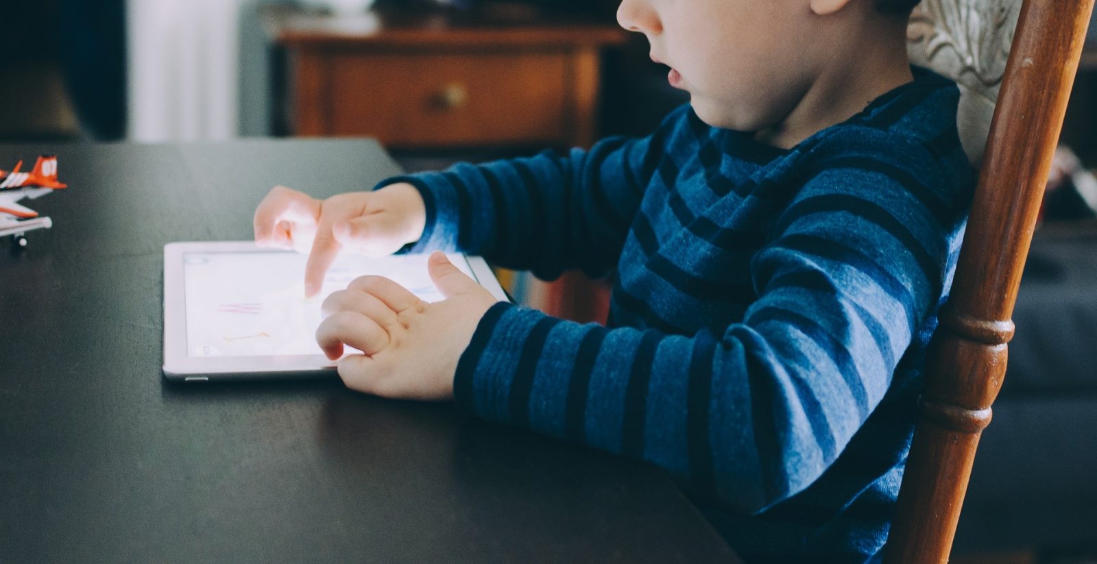 Lille dreng sidder med en iPad