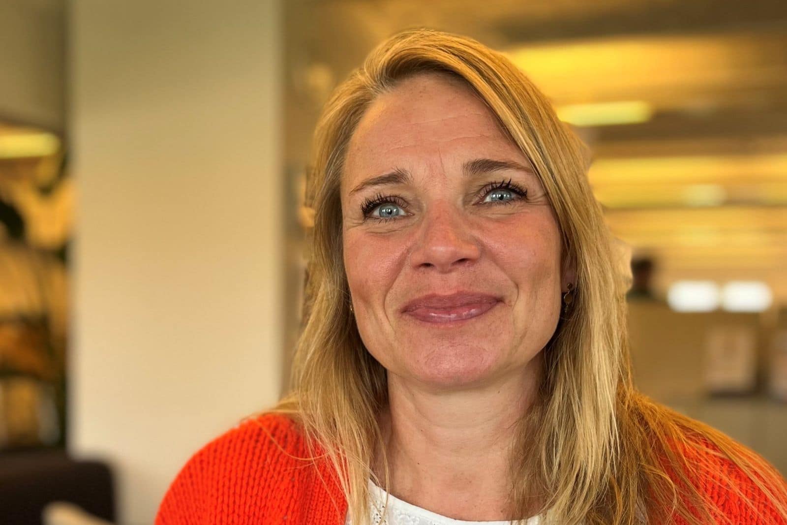 Blond kvinde smiler til kameraet