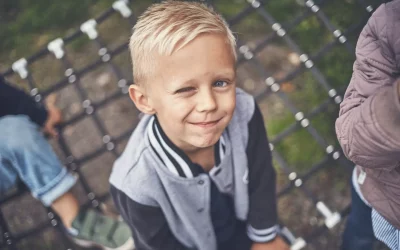 Blond dreng set oppefra, blinker til kameraet