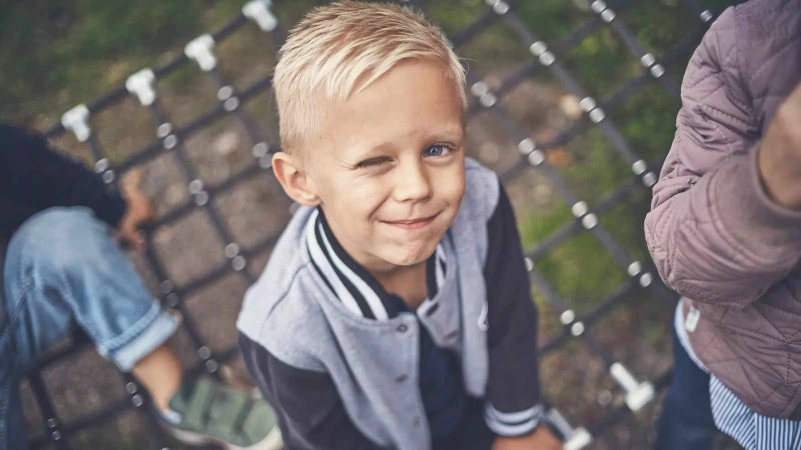 Blond dreng set oppefra, blinker til kameraet