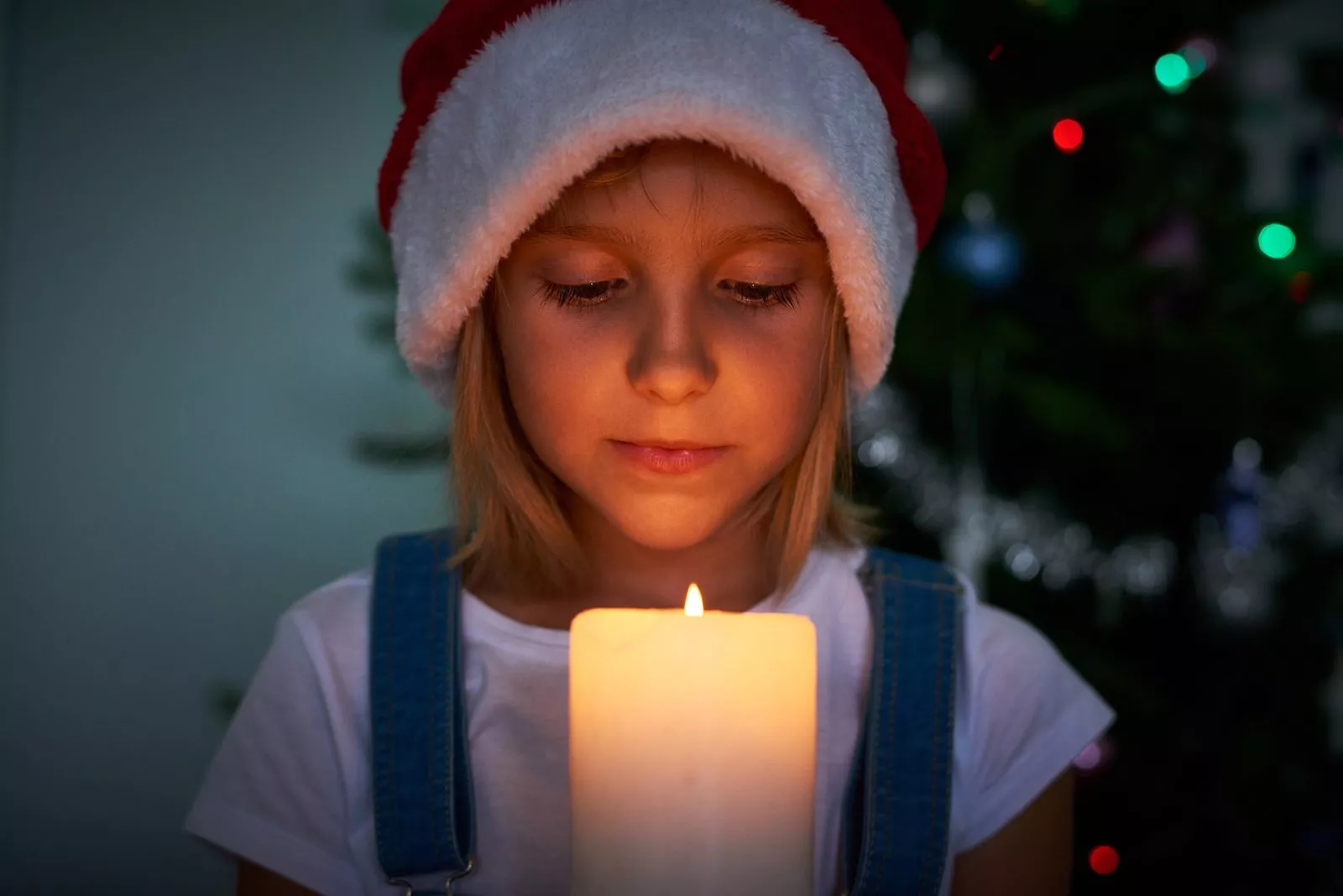Pige i nissehue foran et lys