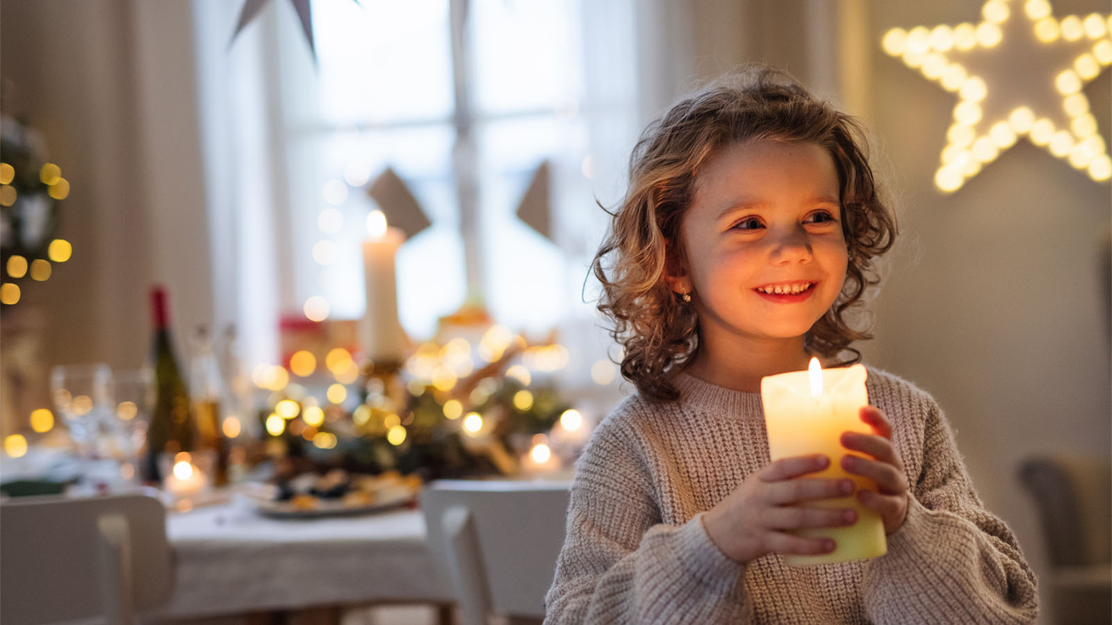 Lille pige med et lys i hænderne