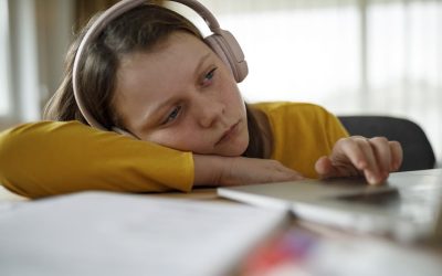 Pige med headset på ligger ind over et bord