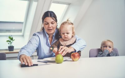 Kvinde sidder med barn og skærer æbler