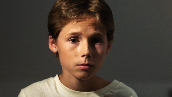 Brunhåret dreng kigger ind i kameraet