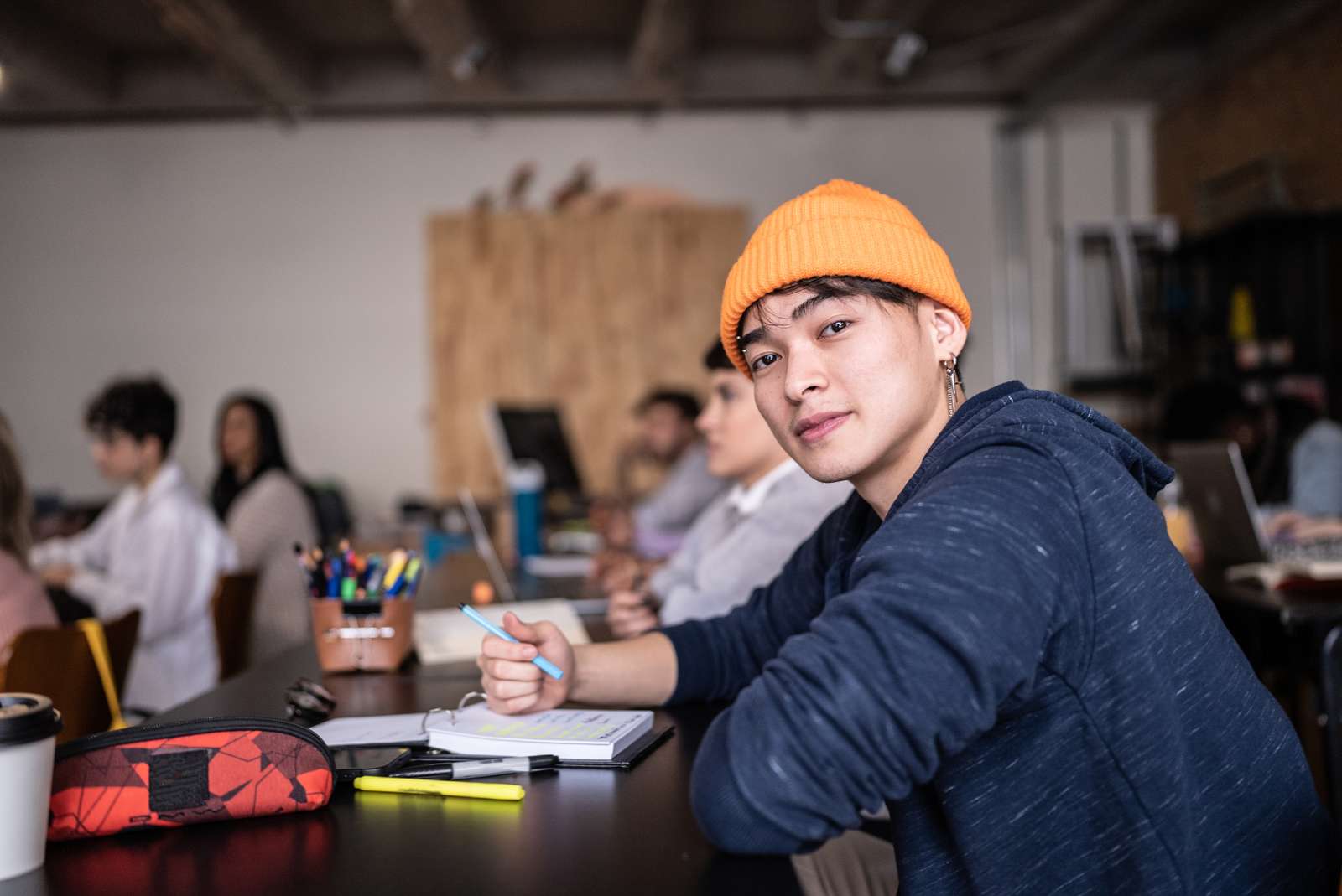 Dreng med hue sidder ved et bord