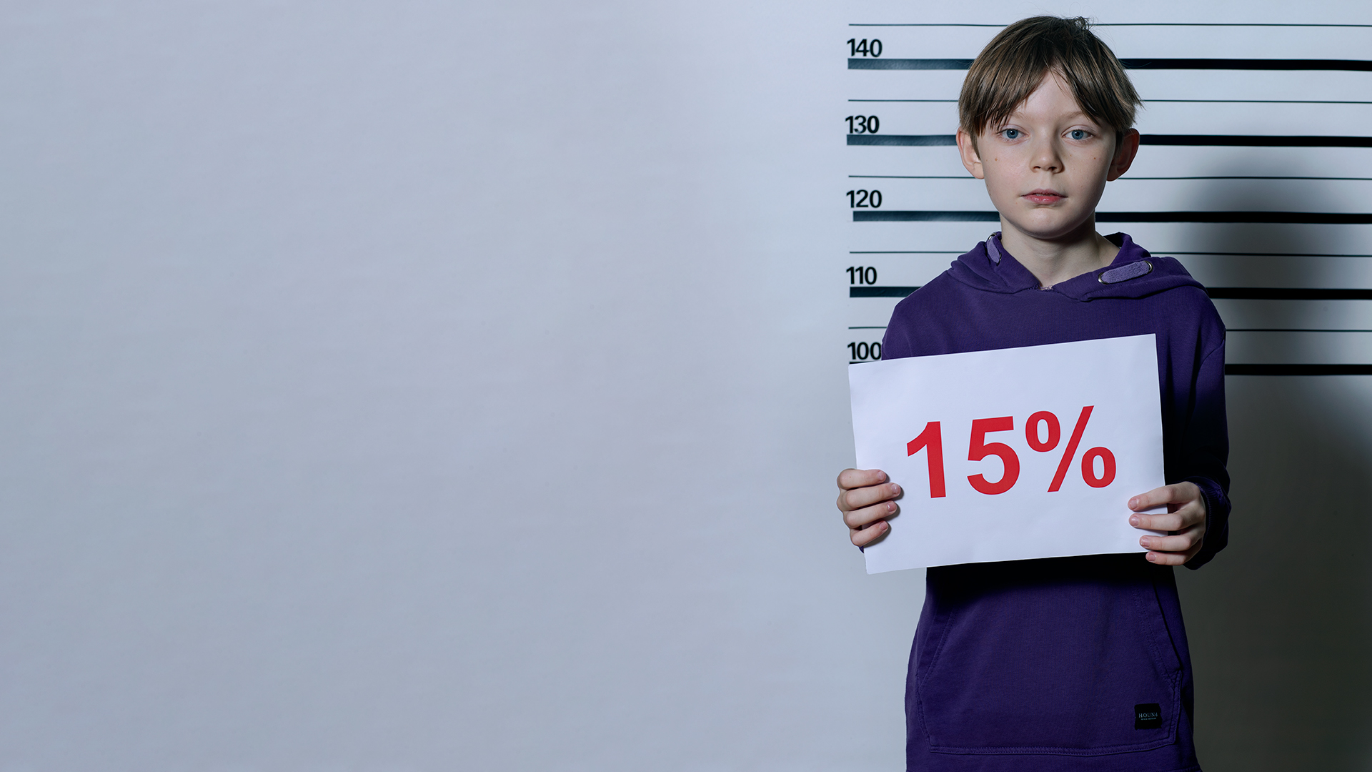 Forbryderbillede af en dreng med et skilt der signalere 15% fravær