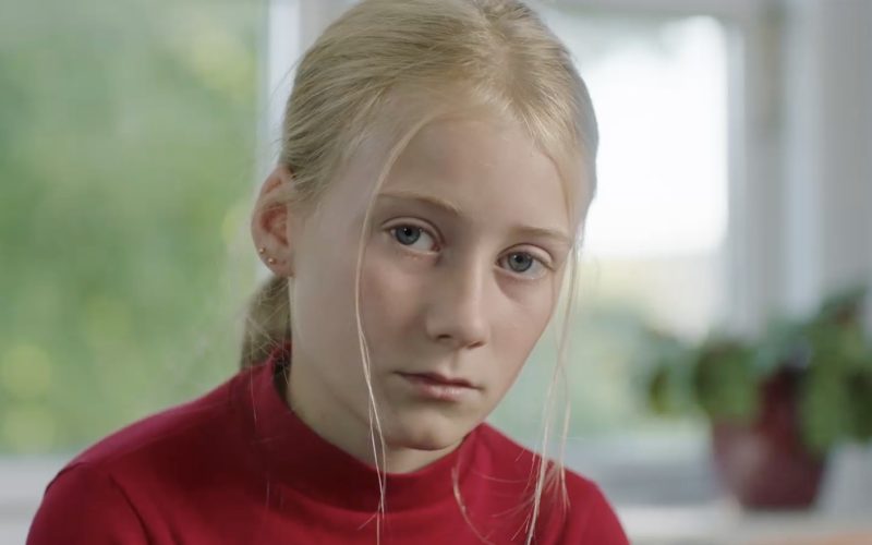 Lyshåret pige kigger ind i kameraet