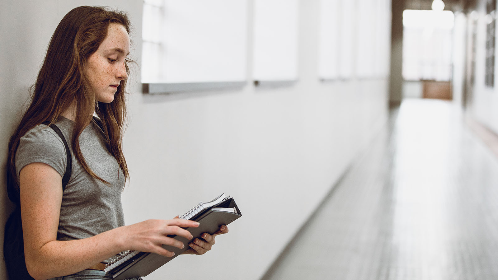 Rådhåret pige i gang kigger ned på et hæfte.