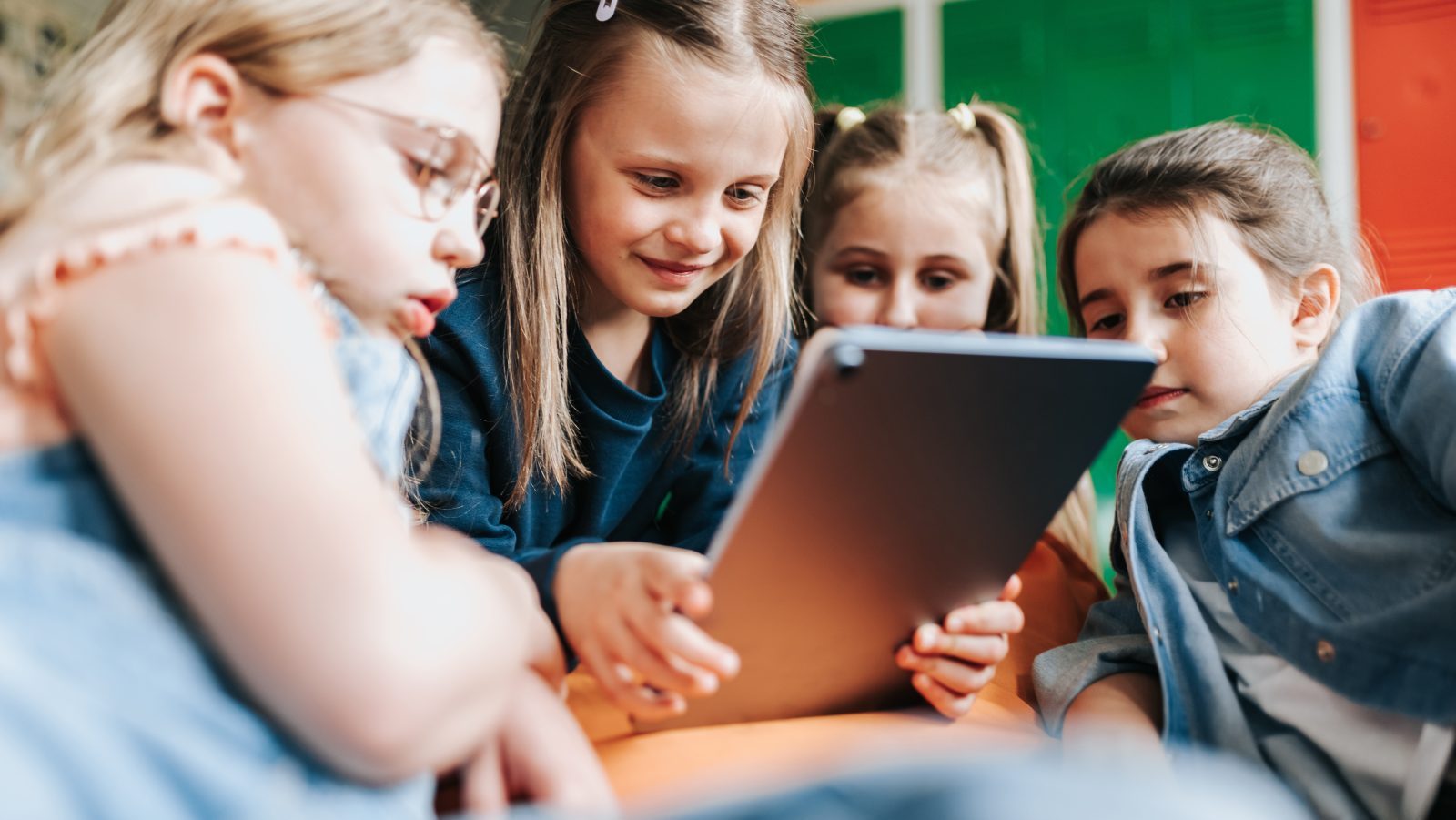 Fire skolepiger kigger på en tablet sammen