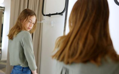 Pige der kigger selv i spejlet i et prøverum