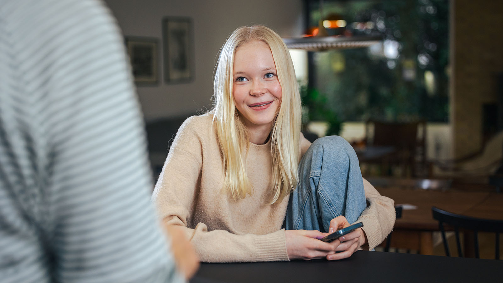 Pige sidder med sin telefon