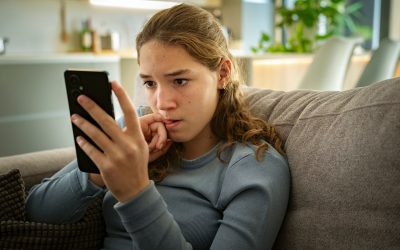 Pige kigger bekymret på sin mobil