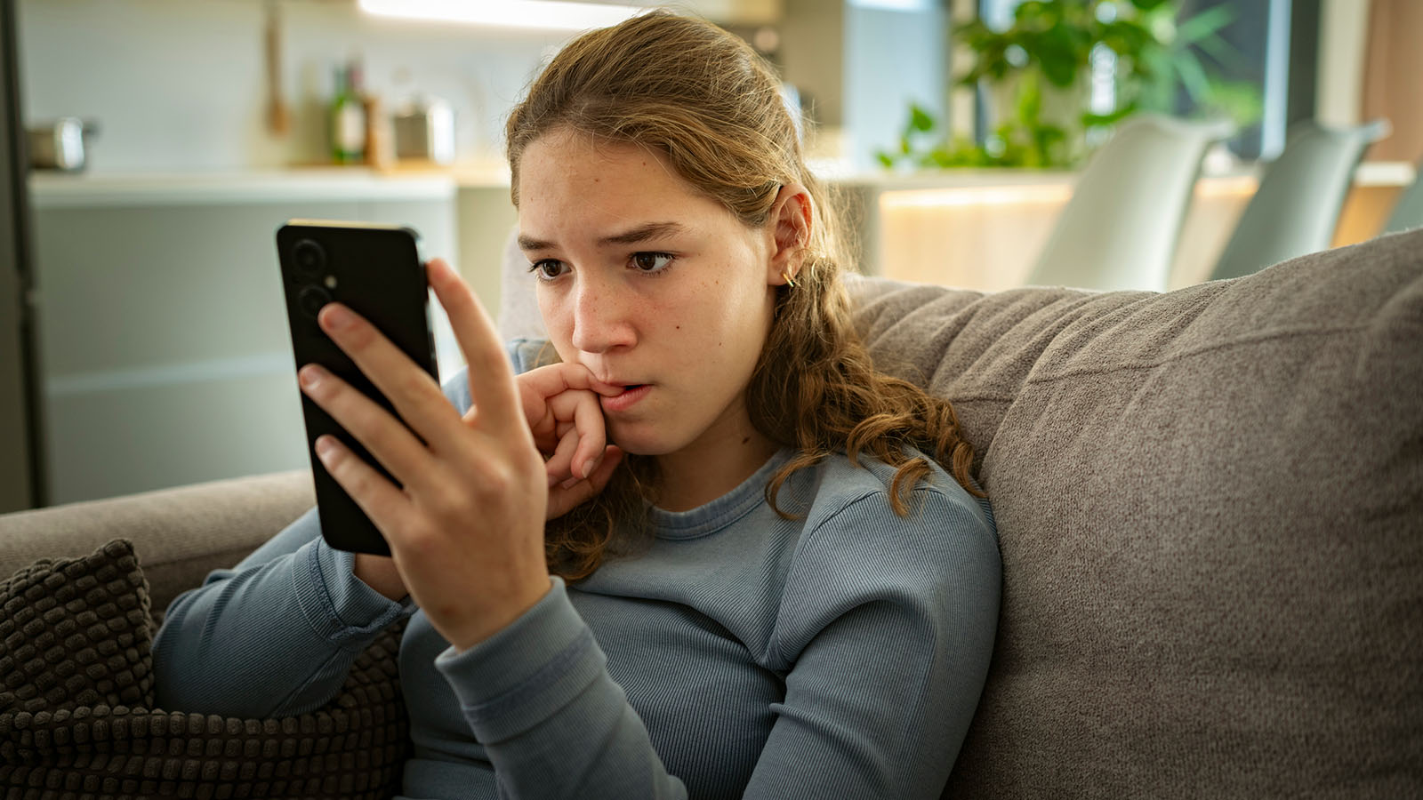 Pige kigger bekymret på sin mobil