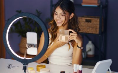 Pige sidder foran sin telefon med sin makeup