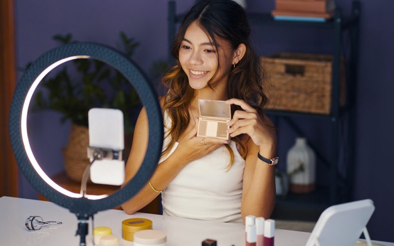 Pige sidder foran sin telefon med sin makeup