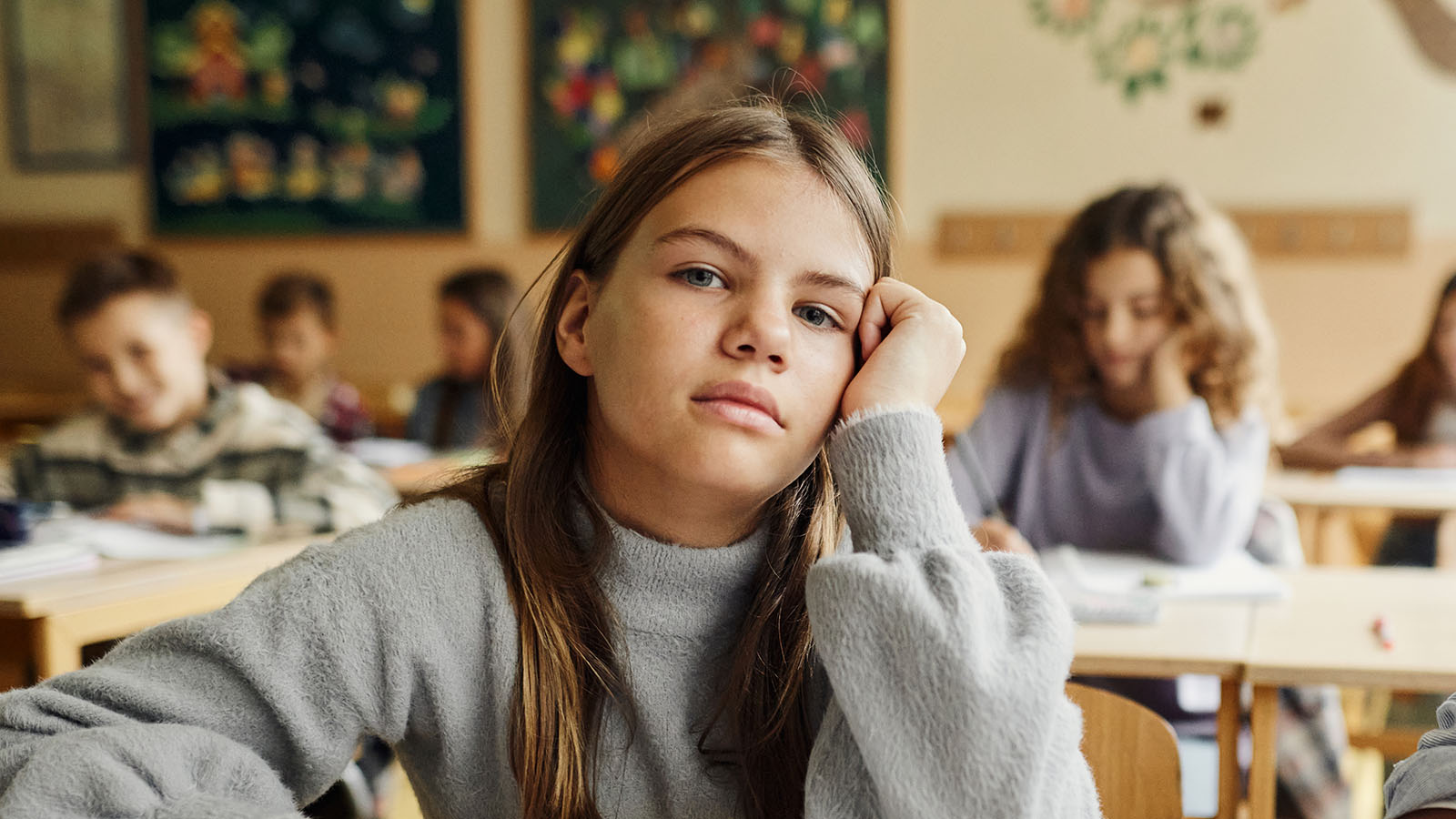 Pige i en skoleklasse, der kigger direkte ind i kameraet