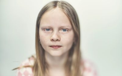Pige på hvid baggrund kigger ind i kameraet