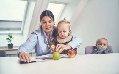 Kvinde sidder med barn og skærer æbler